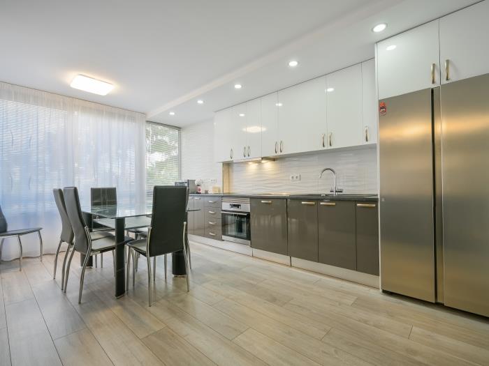 Open plan kitchen with modern appliances and dining table for 6