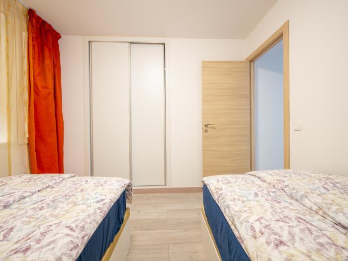 Recessed wardrobes and two single beds in bedroom