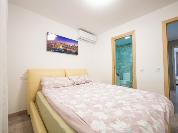 Air conditioner, recessed wardrobes and double bed in bedroom